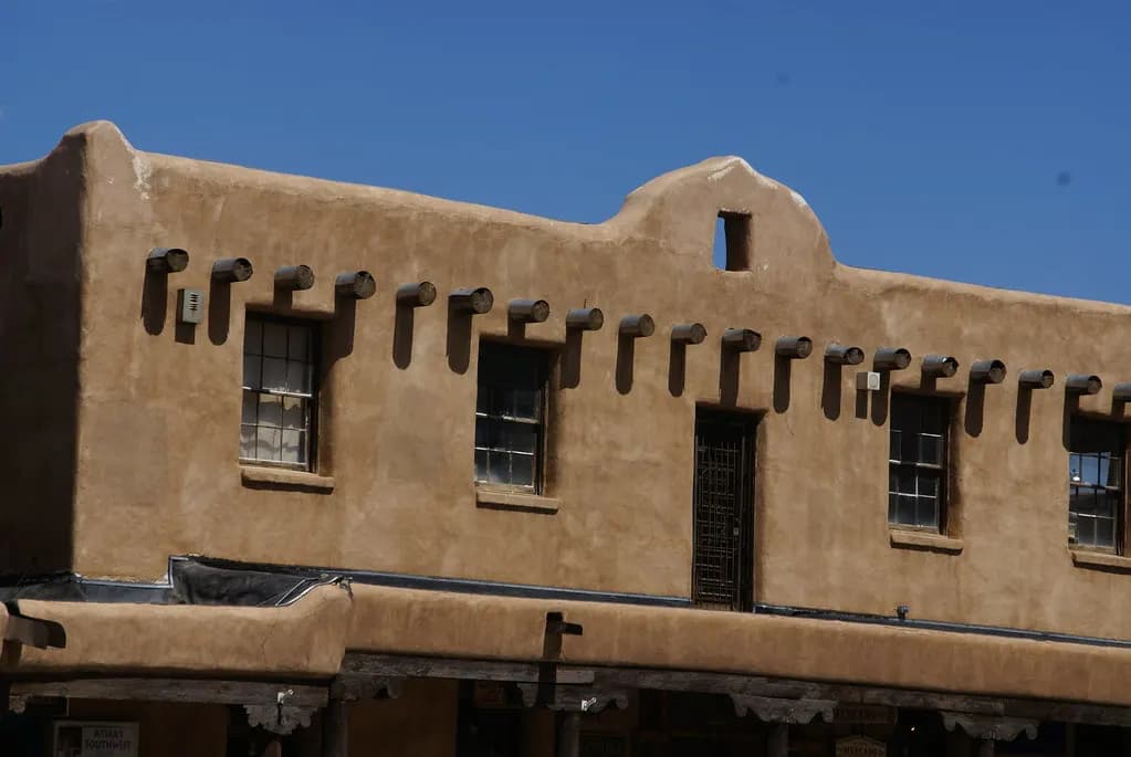 Adobe building with projecting roof beams and a covered walkway in Taos, New Mexico