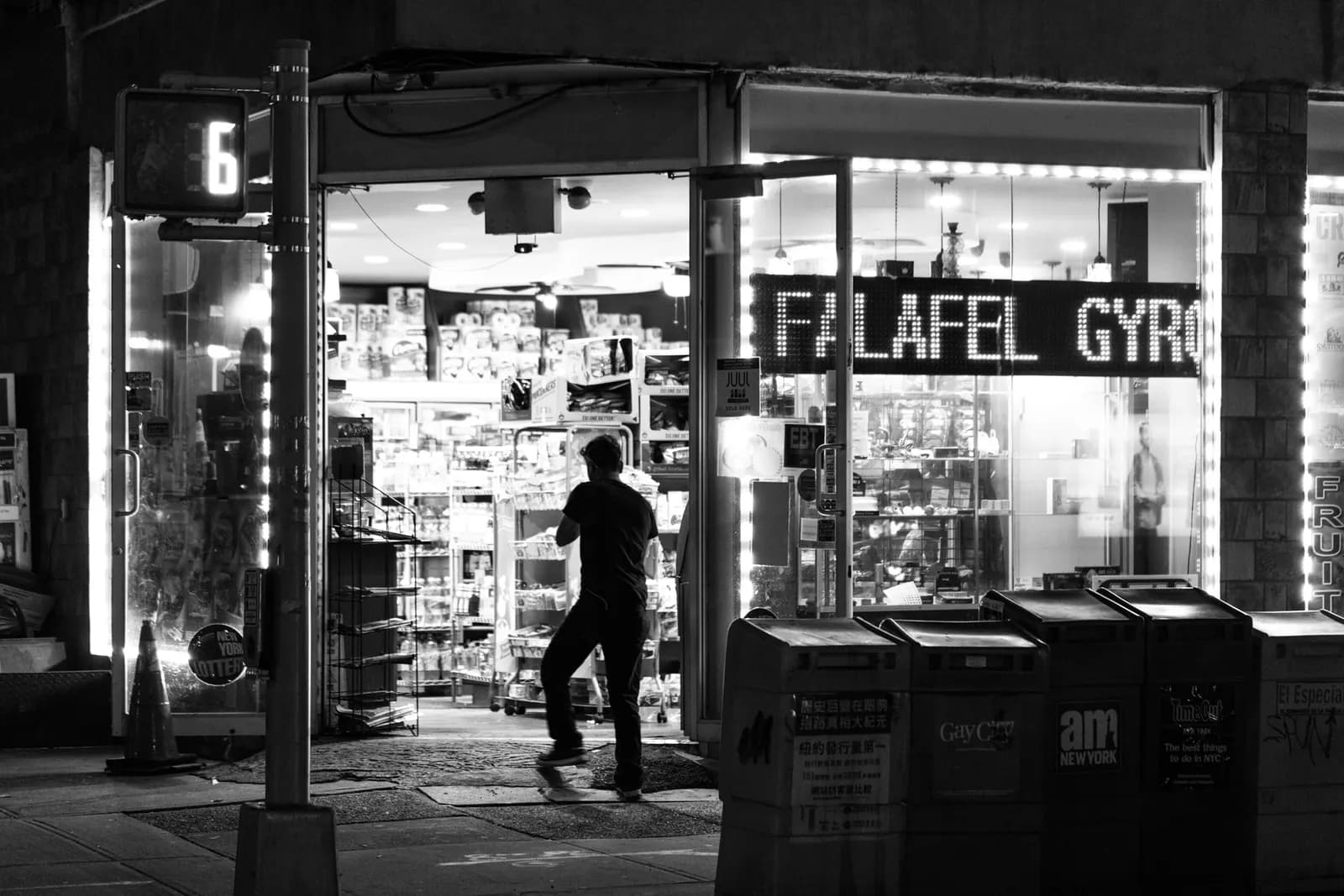 A corner bodega with awning and window displays on a New York City street