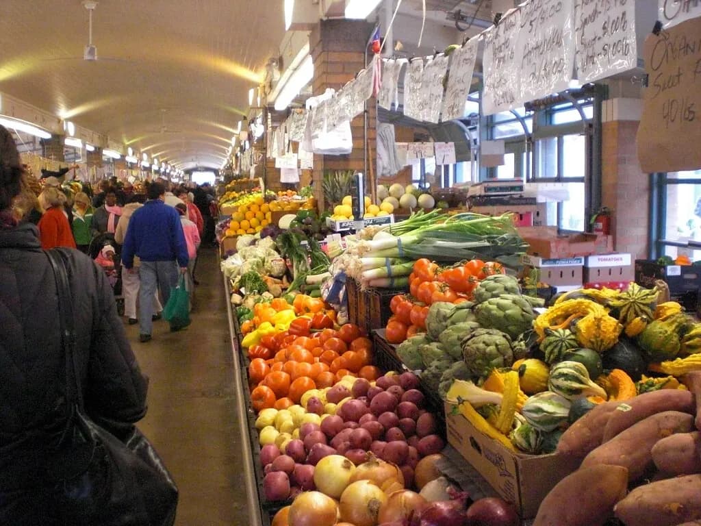 Stalls of tomatoes, onions, potatoes, artichokes and squash inside Cleveland's West Side Market