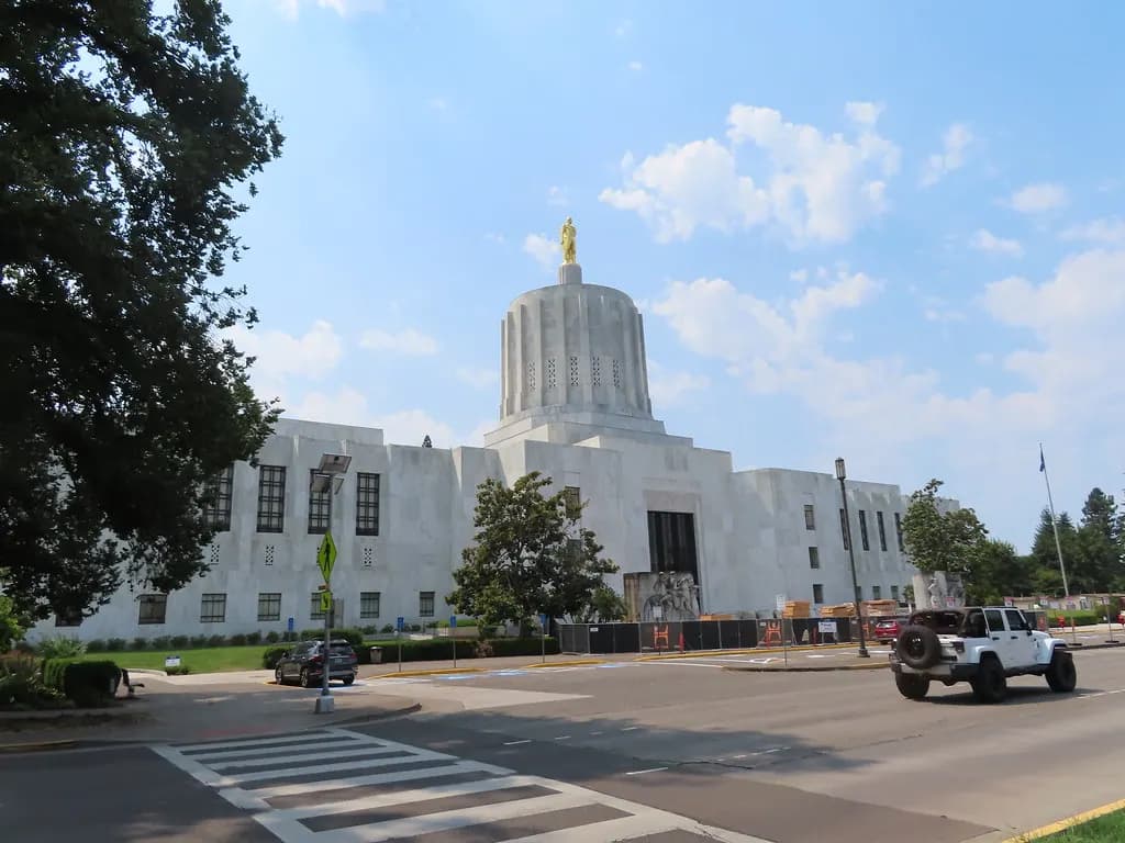 The Oregon State Capitol in Salem, a white marble building topped by a fluted drum tower and the gold Oregon Pioneer statue