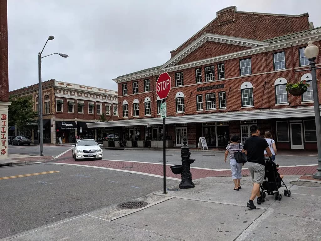 A two-story brick commercial building with ground-floor shops on a downtown street corner