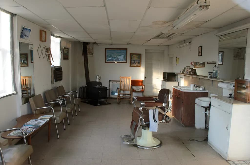 Interior of a small-town barber shop in Bryson City, North Carolina, with a barber chair, waiting chairs and a wash station