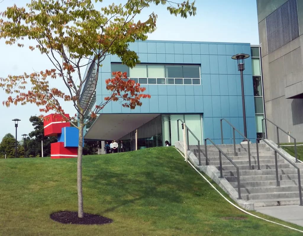 Modern blue and glass WorkSource building in North Seattle with a young tree and steps leading to the entrance