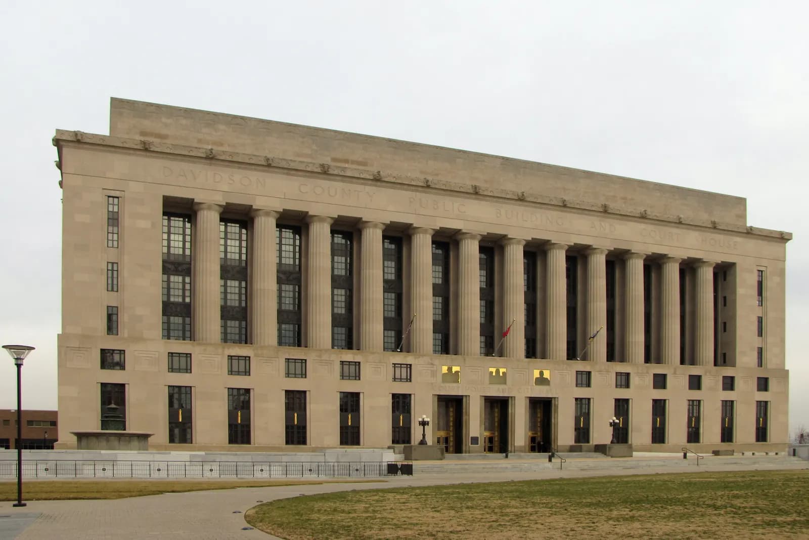 The Historic Metro Courthouse in Nashville, a long limestone building with a row of tall columns, seen across a lawn