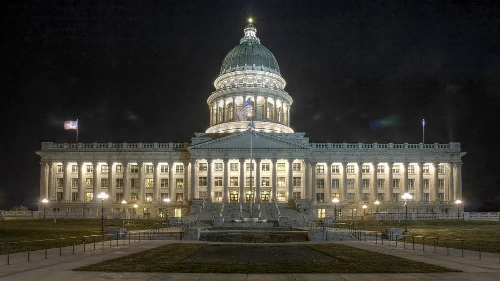 The Utah State Capitol in Salt Lake City lit up at night, with its copper dome and columned facade